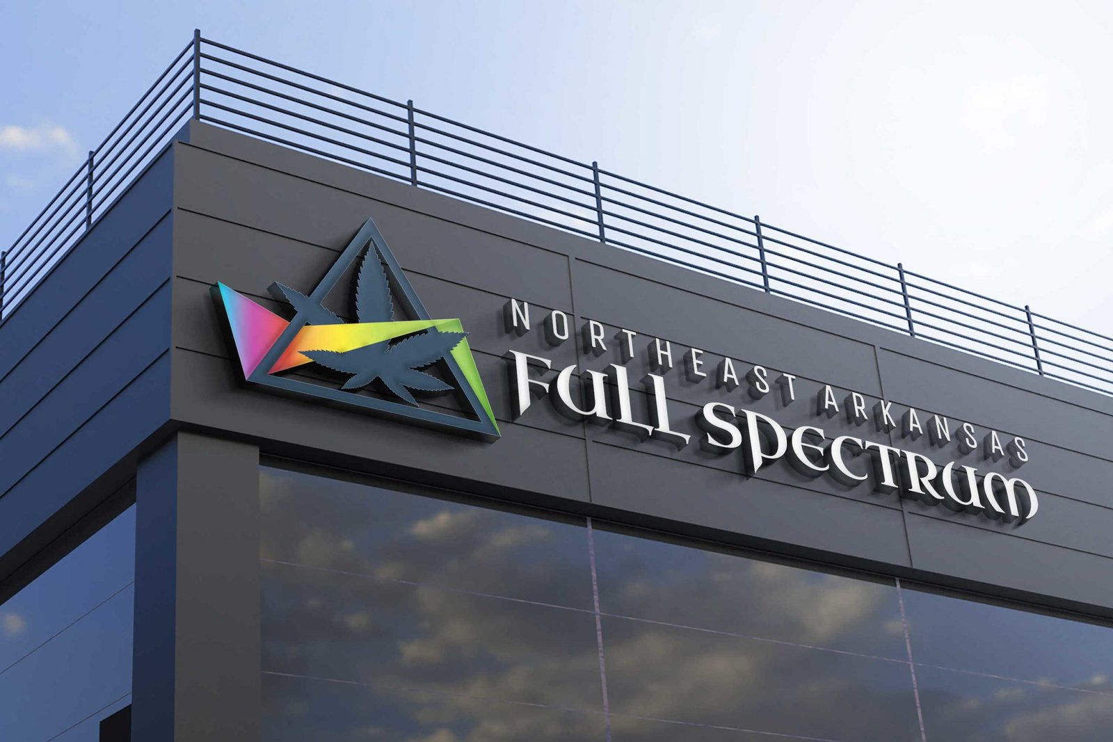 The logo as a dimensional sign mounted on a modern building exterior against a blue sky.