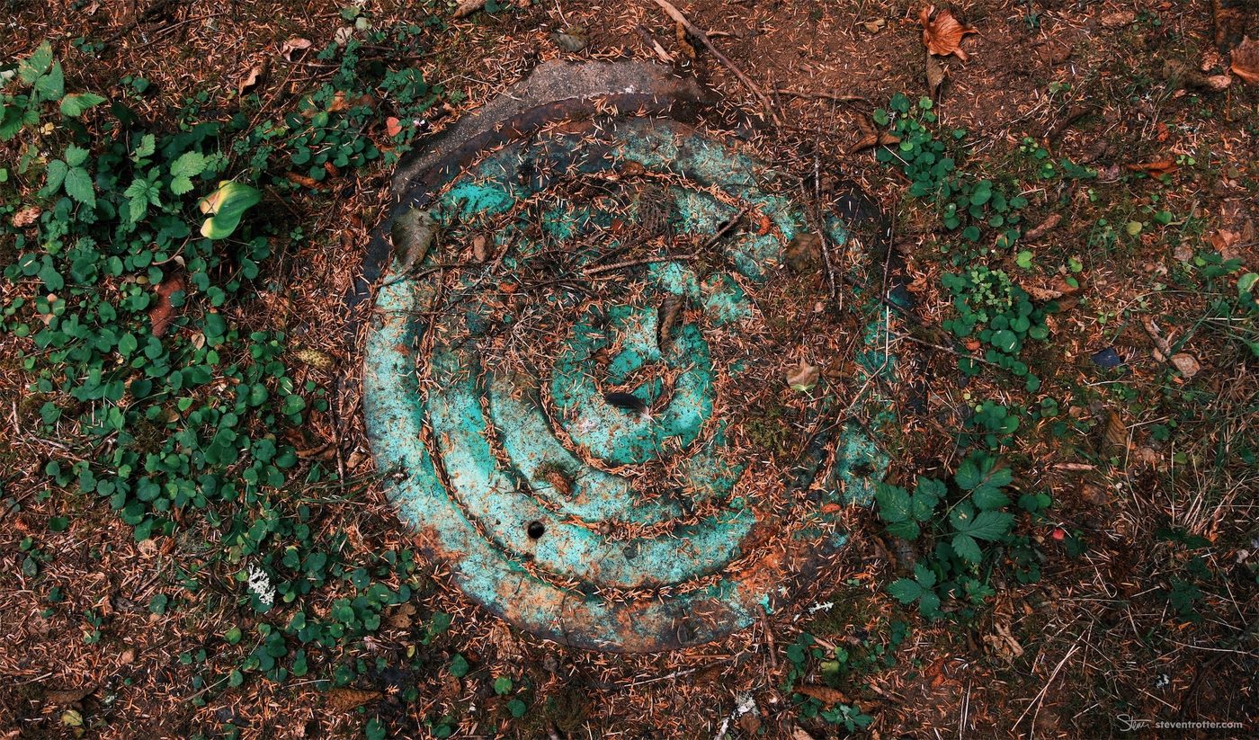 Rusty Manhole Cover In Forest.