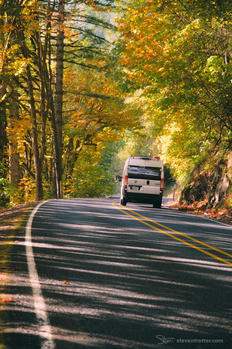 Van Driving Through Autumn Forest.